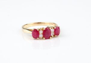 A 14ct gold, ruby and diamond seven stone ring - stamped '14K 585', the three oval cut rubies