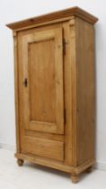 A Victorian style pine cupboard: the flared moulded top over a single panelled door enclosing two