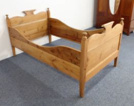 An antique waxed pine single bed - probably Scandinavian, with serpentine head and foot boards