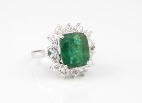 An 18ct white gold, emerald and diamond cluster ring - stamped '18K', the 11 x 9mm. rectangular