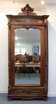 A late 19th century French walnut veneered armoire: the deep, flared cornice with outset corners,