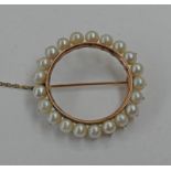 CIRCULAR PEARL SET BROOCH IN A YELLOW METAL MOUNT - 3CM DIAMETER