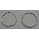 PAIR OF UNMARKED YELLOW METAL TORQUE BANGLES WITH ENGRAVED DECORATION - 69CM INNER DIAMETER, 28.