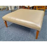 CREAM LEATHERETTE SQUARE CENTRE STOOL ON TAPERED SUPPORTS,