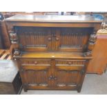 OAK COURT CABINET WITH 2 DECORATIVE PANEL DOORS OVER BASE OF 2 DRAWERS & 2 PANEL DOORS,