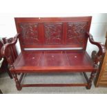 ARTS & CRAFTS STYLE MAHOGANY HALL BENCH WITH DECORATIVE CARVED PANEL BACK ON TURNED SUPPORTS.