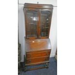 OAK BUREAU BOOKCASE WITH SHELVED INTERIOR BEHIND 2 GLAZED PANEL DOOR OVER BASE WITH FALL FRONT & 2