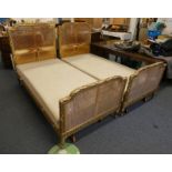 PAIR OF 19TH CENTURY GILT SINGLE BED FRAMES WITH BERGERE PANELS ON REEDED SUPPORTS.