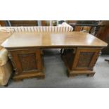 LATE 19TH CENTURY OAK FLAT TOPPED DESK WITH CARVED PANEL DOORS OPENING TO DRAWERS,