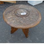 EASTERN HARDWOOD CIRCULAR TABLE WITH CARVED FLORAL DECORATION .