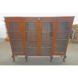 19TH CENTURY STYLE MAHOGANY BREAKFRONT BOOKCASE WITH 4 GLAZED PANEL DOORS ON DECORATIVE SHORT QUEEN