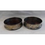 PAIR OF SILVER WINE SLIDES ON MAHOGANY BASES,