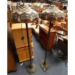 PAIR OF METAL STANDARD LAMPS WITH FAUX LEADED STAINED GLASS SHADES AND REEDED COLUMNS ON DECORATIVE