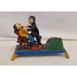 CAST IRON MODEL OF A DENTIST PULLING A TOOTH FROM A PATIENT