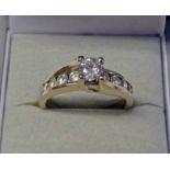 14K GOLD DIAMOND SOLITAIRE WITH DIAMOND INSET SHOULDERS, THE PRINCIPAL DIAMOND APPROX 0.