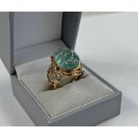 18CT GOLD CARVED AQUAMARINE SET RING IN PIERCED MOUNT - 11.
