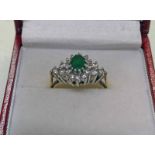 9CT GOLD DIAMOND AND EMERALD CLUSTER RING THE OVAL EMERALD IN A SURROUND OF 18 BRILLIANT CUT