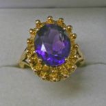 9CT GOLD AMETHYST SET RING, THE OVAL FACETED AMETHYST SET WITHIN A DECORATIVE STUDDED MOUNT - 6.