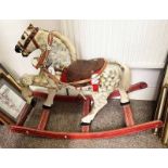 EARLY 20TH CENTURY PAINTED WOOD ROCKING HORSE WITH LEATHER SADDLE AND STRAPS ON A WOODEN BASE,