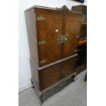 20TH CENTURY WALNUT COCKTAIL CABINET WITH 2 PANEL DOOR WITH DECORATIVE BRASS FIXTURES OPENING TO