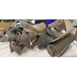 6 VARIOUS SIZED LEATHER SADDLES & A LEATHER & METAL CONTAINER