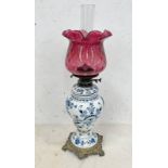 BLUE & WHITE PORCELAIN BODIED PARAFFIN LAMP WITH CRANBERRY GLASS SHADE