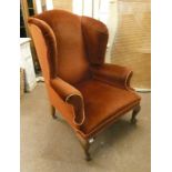 EARLY 20TH CENTURY OVERSTUFFED WINGBACK ARMCHAIR ON SHORT QUEEN ANNE SUPPORTS