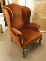 EARLY 20TH CENTURY OVERSTUFFED WINGBACK ARMCHAIR ON SHORT QUEEN ANNE SUPPORTS