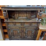 19TH CENTURY STYLE OAK COURT CUPBOARD WITH DECORATIVE FRIEZE OVER SINGLE INLAID PANEL DOOR FLANKED