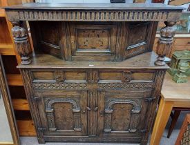 19TH CENTURY STYLE OAK COURT CUPBOARD WITH DECORATIVE FRIEZE OVER SINGLE INLAID PANEL DOOR FLANKED