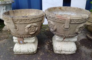 PAIR OF RECONSTITUTED STONE GARDEN URNS WITH FLORAL DECORATION ON PLINTH BASES.