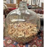 GLASS CARBOY WITH CONTENTS OF WINE CORKS 47CM TALL