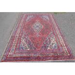 TERRACOTTA GROUND PERSIAN / VILLAGE CARPET WITH CENTRAL MEDALLION DESIGN 305 X 210CM