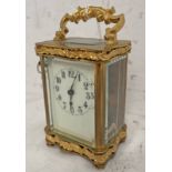 BRASS CARRIAGE CLOCK WITH WHITE DIAL, GLASS PANELS , EMBOSSED DECORATION TO TOP & BOTTOM,