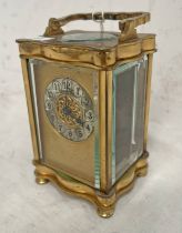GILT METAL CARRIAGE CLOCK WITH SILVERED CIRCULAR DIAL ON TURNED SUPPORTS,
