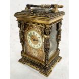 20TH CENTURY GILT METAL CARRIAGE CLOCK WHITE ENAMEL DIAL SURROUNDED BY GILT METAL FOLIAGE & WINGED