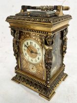 20TH CENTURY GILT METAL CARRIAGE CLOCK WHITE ENAMEL DIAL SURROUNDED BY GILT METAL FOLIAGE & WINGED
