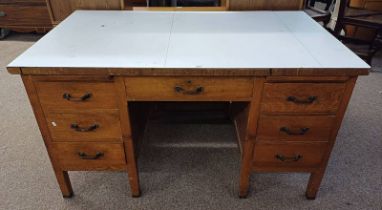 OAK DESK WITH FORMICA TOP[ & 7 DRAWERS ON SQUARE SUPPORTS.