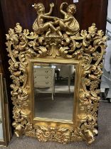 OVERMANTLE MIRROR WITH DECORATIVE CARVED GILT FRAME SURMOUNTED BY 2 CHERUBS,