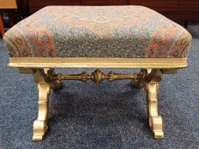 CARVED GILT SQUARE STOOL WITH PADDED TOP ON X - SUPPORTS.