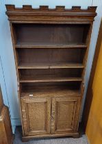 EARLY 20TH CENTURY OAK BOOKCASE WITH CASTELLATED CORNICE OVER SHELVES WITH 2 PANELLED DOORS ON