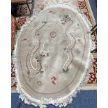 CREAM OVAL ORIENTAL RUG DECORATED WITH A DRAGON,