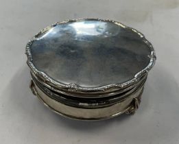 SILVER CIRCULAR JEWELLERY BOX ON 3 SUPPORTS WITH PADDED INTERIOR,