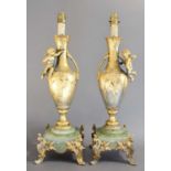 A Pair of French Gilt Metal and Onyx Lamp Bases, of baluster form applied with putti, on scroll cast