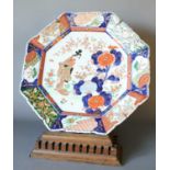 An Imai Porcelain Fluted Octagonal Charger, decorated with a bijin in a garden landscape under a