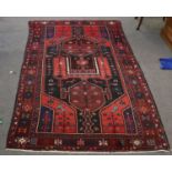 A Kurdish Long Rug, the charcoal field with trival motifs, plants and birds enclosed by stellar