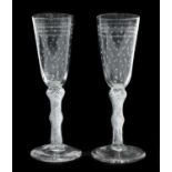 A Pair of Ale Flutes, circa 1750, the rounded funnel bowls engraved with stars on double knopped air