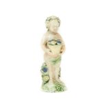 A Whieldon Type Creamware Figure of a Flower Attendant, circa 1770, as a standing putto with a