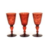 A Set of Three Bohemian Glass Goblets, 19th century, the rounded funnel bowls engraved with