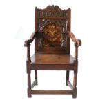 A 17th Century Joined Oak Wainscot Armchair, the scrolled and carved back support surrounding a